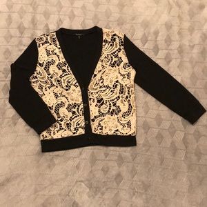 Black and cream colored cardigan with four buttons